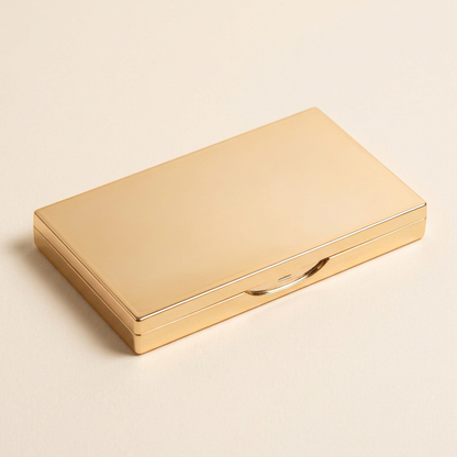 Illustrative closed gold-tone compact exterior neatly displayed.