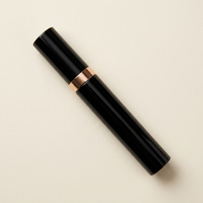 Single fully capped mascara tube neatly laid flat.